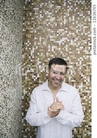 Hispanic man in front of tile wall 11636703