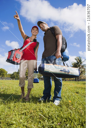 Hispanic couple carrying camping supplies Hispanic couple carrying camping supplies 11636707