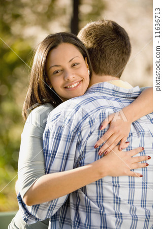 Hispanic woman hugging boyfriend Hispanic woman hugging boyfriend 11636713