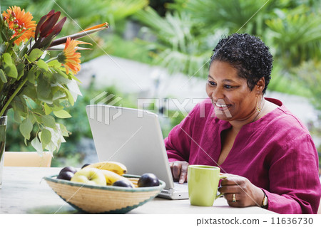Middle-aged African woman using laptop outdoors 11636730