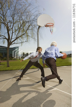 Two businessmen playing basketball Two businessmen playing basketball 11636731