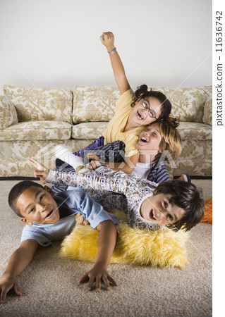 Group of children playing on the living room floor 11636742