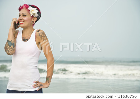 Tattooed Hispanic woman talking on cell phone Tattooed Hispanic woman talking on cell phone 11636750