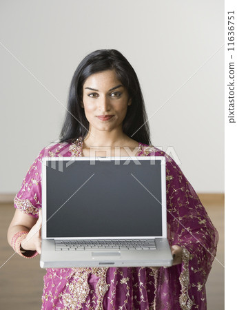 Indian woman holding laptop Indian woman holding laptop 11636751