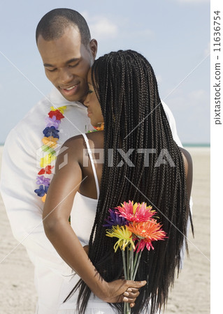 African couple hugging at beach 11636754