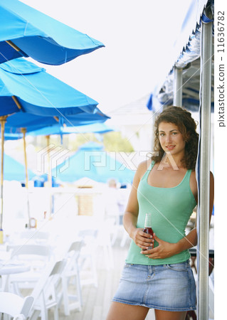 Young woman with drink at beach 11636782