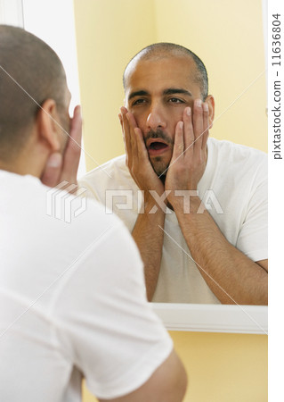 Middle Eastern man looking in mirror Middle Eastern man looking in mirror 11636804