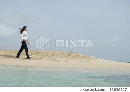 Woman carrying clock at beach Woman carrying clock at beach 11636827