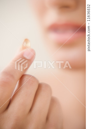 Close up of fingers holding vitamin Close up of fingers holding vitamin 11636832
