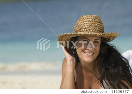 Hispanic woman wearing straw hat 11636877