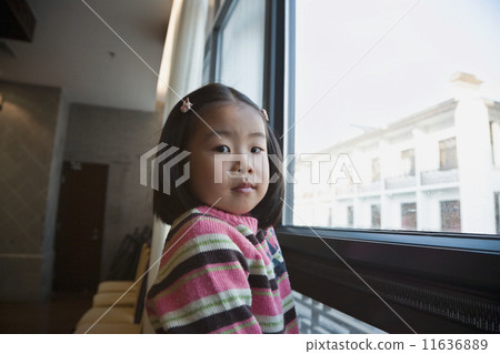 Asian girl next to window 11636889
