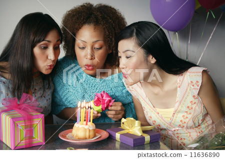 Women blowing out birthday candles 11636890