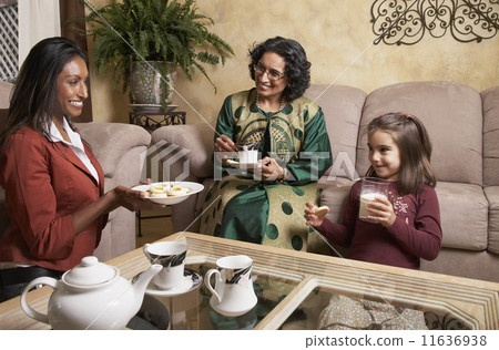 Multi-generational Indian female family members having snack Multi-generational Indian female family members having snack 11636938