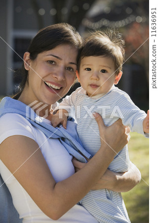 Hispanic mother holding baby outdoors 11636951