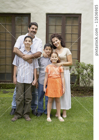 Hispanic family in front of house 11636985