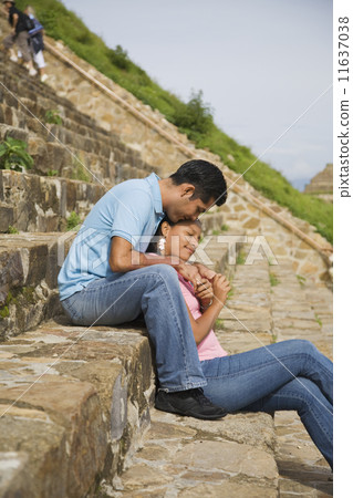 Hispanic couple sitting on stone steps, Oaxaca, Mexico 11637038