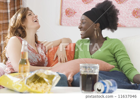 Two women laughing on sofa Two women laughing on sofa 11637046