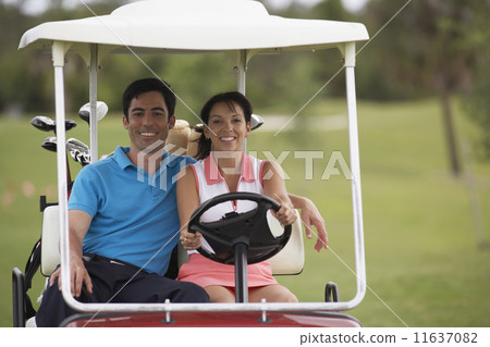 Hispanic couple driving golf cart Hispanic couple driving golf cart 11637082