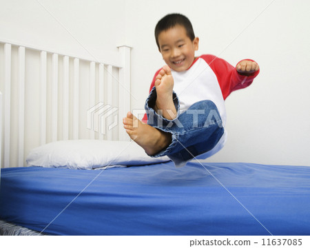 Asian boy jumping on bed Asian boy jumping on bed 11637085