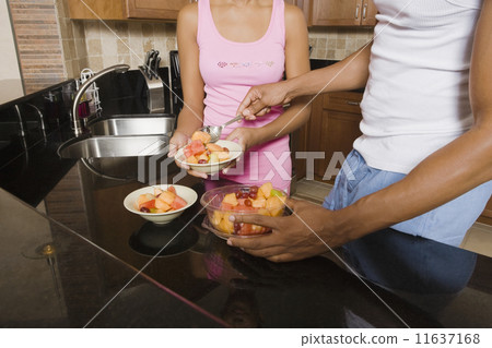 African couple eating fruit salad 11637168