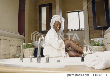 African American woman in bathroom wearing bathrobe 11637191