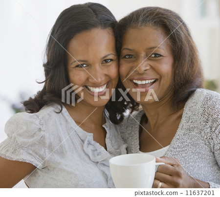African American mother and adult daughter hugging African American mother and adult daughter hugging 11637201