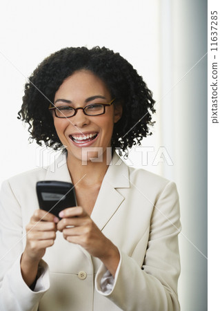 African businesswoman looking at cell phone 11637285