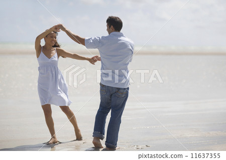 Hispanic couple dancing at beach Hispanic couple dancing at beach 11637355