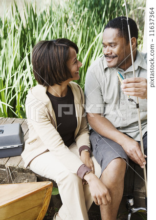 Middle-aged African couple smiling with fishing gear Middle-aged African couple smiling with fishing gear 11637364