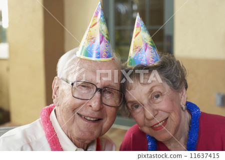 Senior couple wearing party hats 11637415