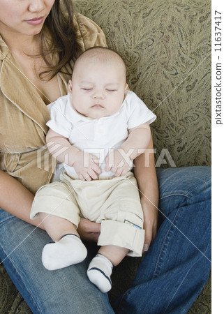 Asian mother holding sleeping baby Asian mother holding sleeping baby 11637417