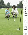 Mother teaching son to play golf 11637419