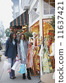 Two women on th sidewalk shopping  11637421