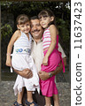 Hispanic father hugging daughters 11637423