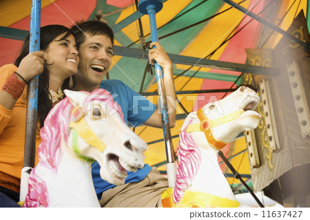 Couple riding a rollercoaster Couple riding a rollercoaster 11637427