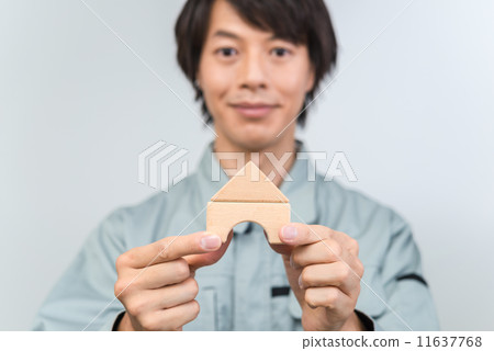 一名身穿工作服的男子正在用積木搭建房子。 11637768