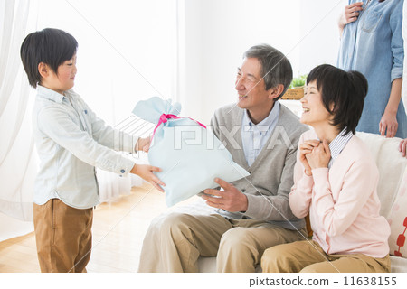 A grandchild giving gifts to grandparents 11638155