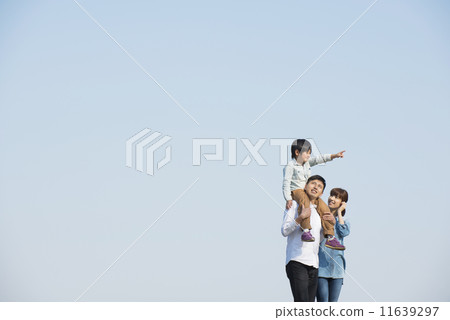 Parent and child walking under blue sky 11639297