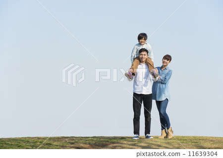 Parent and child walking under blue sky 11639304
