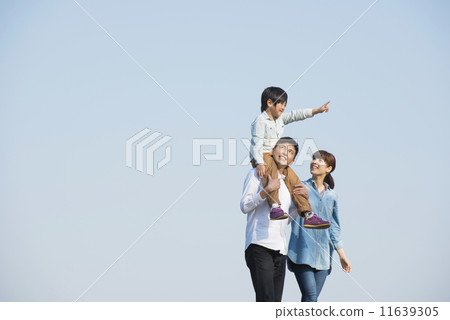 Parent and child walking under blue sky 11639305