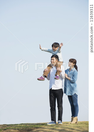Parent and child walking under blue sky 11639311