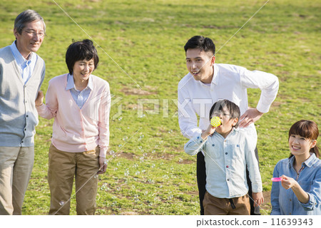 Three generations family enjoying soap bubbles 11639343