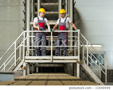 Two men in a safety hats on a factory Two men in a safety hats on a factory 11640449