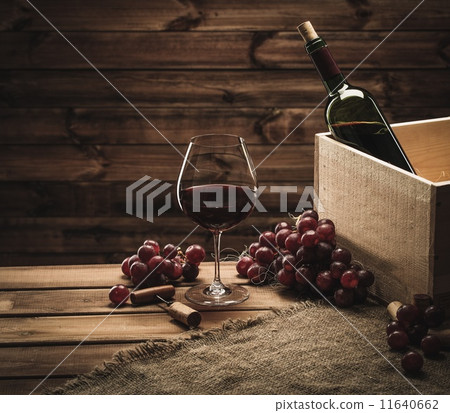 Bottle, glass and red grape on a wooden table Bottle, glass and red grape on a wooden table 11640662