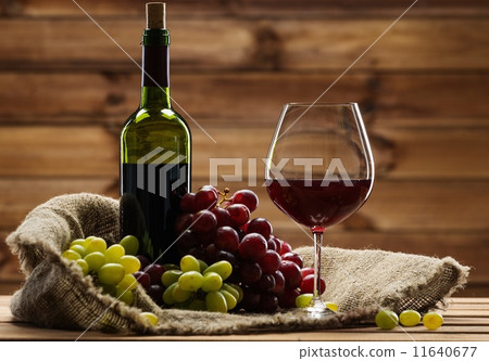 Bottle of red wine, glass and grape on a sack in wooden interior Bottle of red wine, glass and grape on a sack in wooden interior 11640677