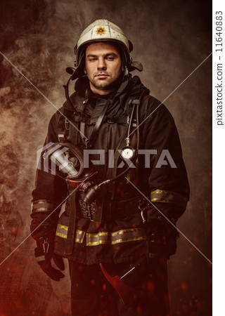 Firefighter with helmet and axe in a smoke 11640883