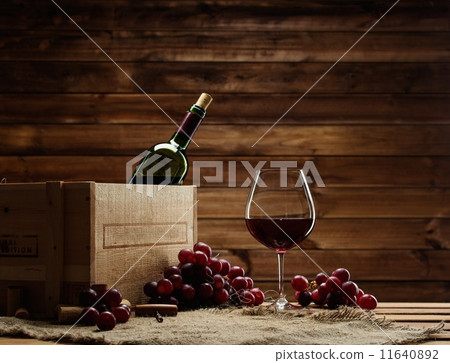 Bottle, glass and red grape on a wooden table Bottle, glass and red grape on a wooden table 11640892