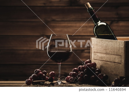 Bottle, glass and red grape on a wooden table Bottle, glass and red grape on a wooden table 11640894