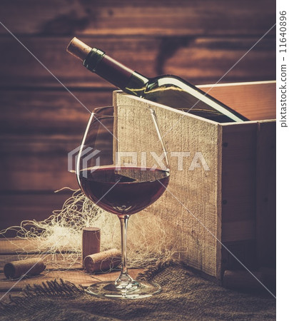 Bottle and glass of red wine on a wooden table Bottle and glass of red wine on a wooden table 11640896