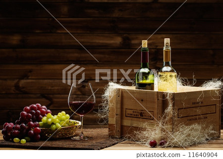 Bottles of red and white wine, glass and grape on a wooden interior Bottles of red and white wine, glass and grape on a wooden interior 11640904
